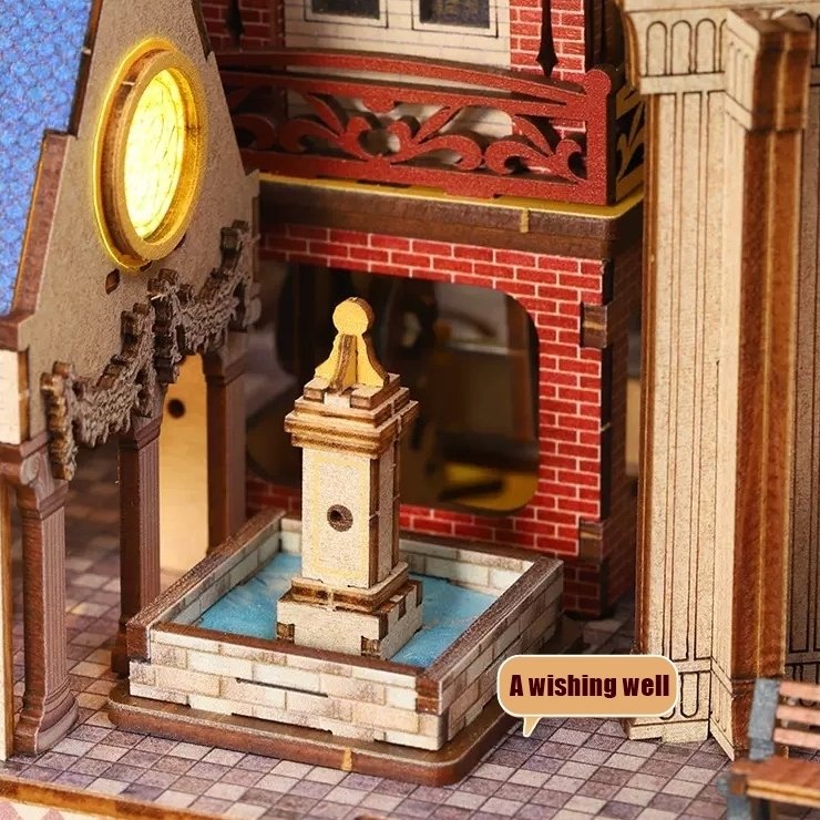 Detailed wooden model of a wishing well with a clock tower and brick wall in the background.