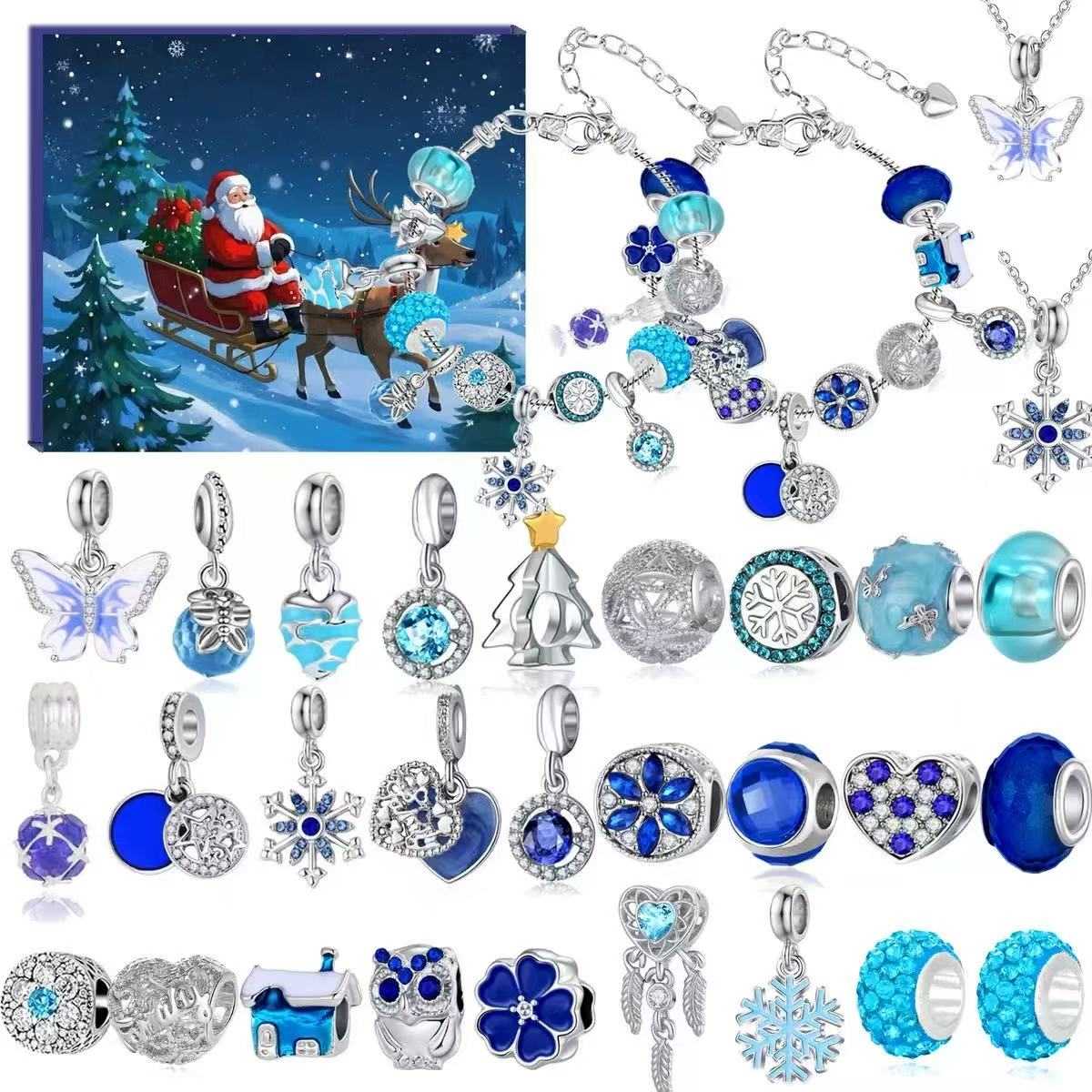 Collection of blue and silver jewelry charms with a Christmas-themed box in the background.