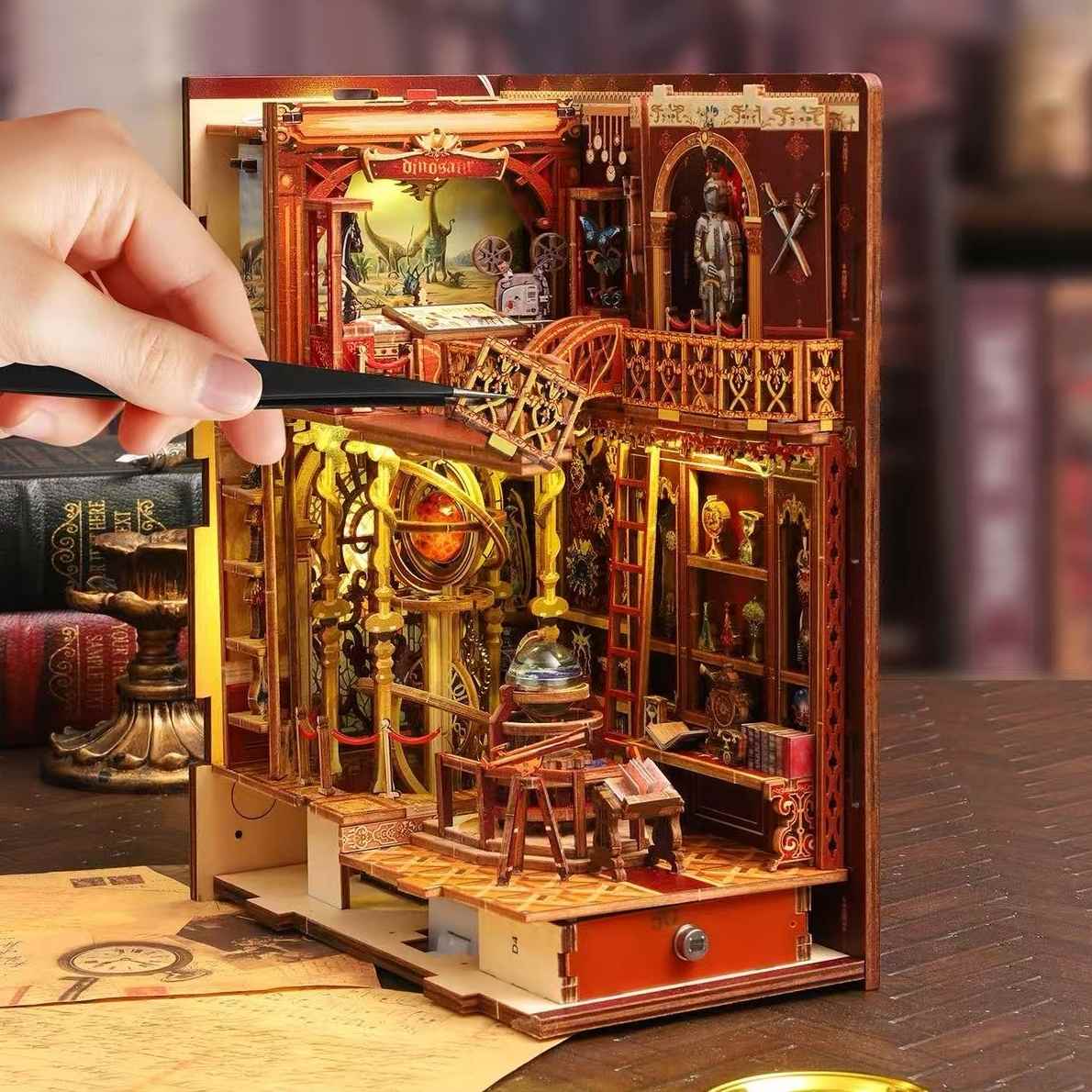 Wooden model of a miniature museum with intricate details, held open by a hand.