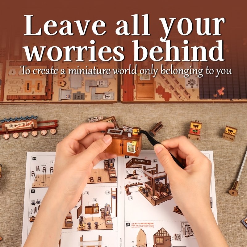 Miniature model of a Japanese Izakaya building set with hands assembling pieces, text 'Leave all your worries behind'