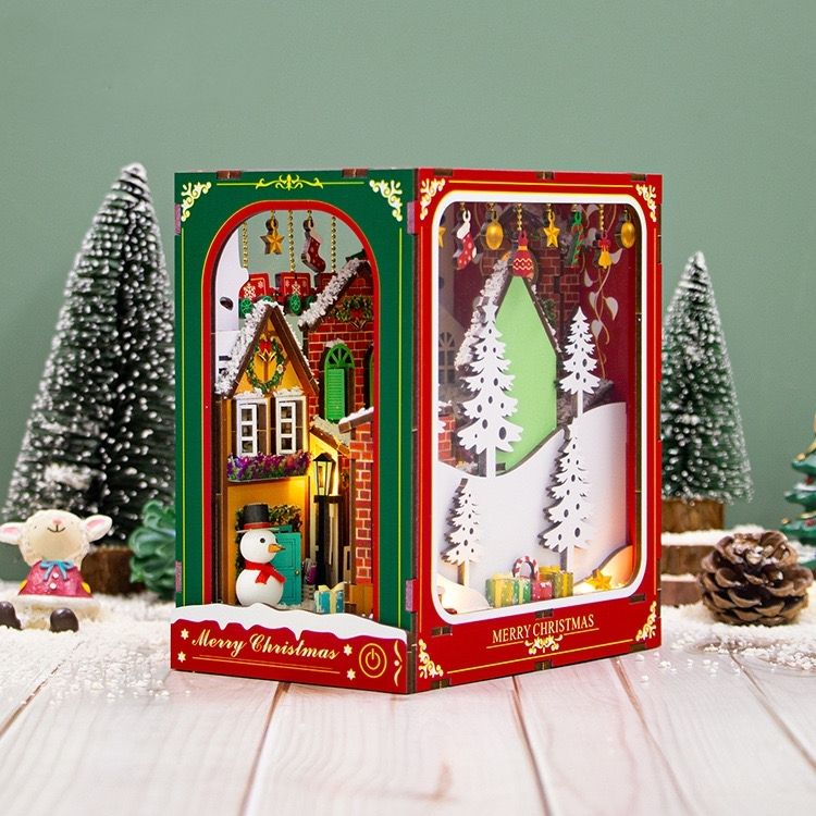 image displaying right side view of the assembled Christmas Winter DIY Book Nook kit in a Christmas-themed table setting