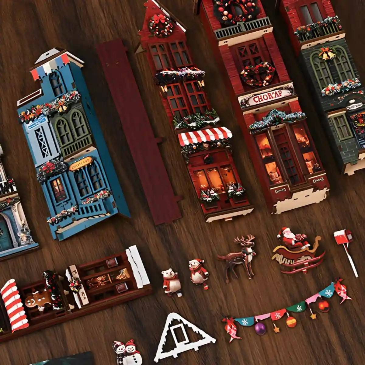 Collection of decorative Christmas  miniature buildings and figures on a wooden surface.