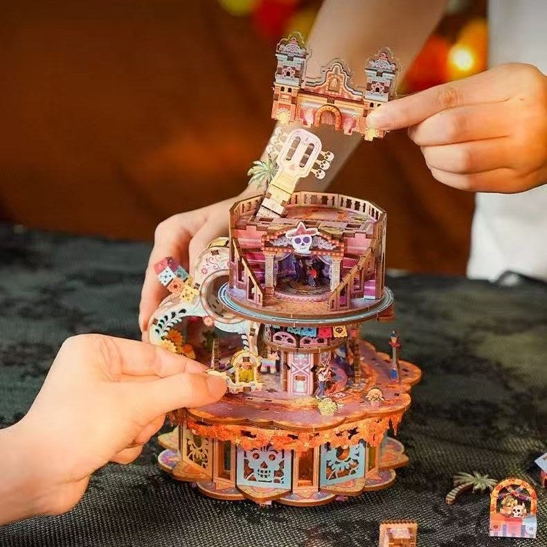 hands holding a colorful Coco-inspired 3D puzzle model of a music box with intricate details