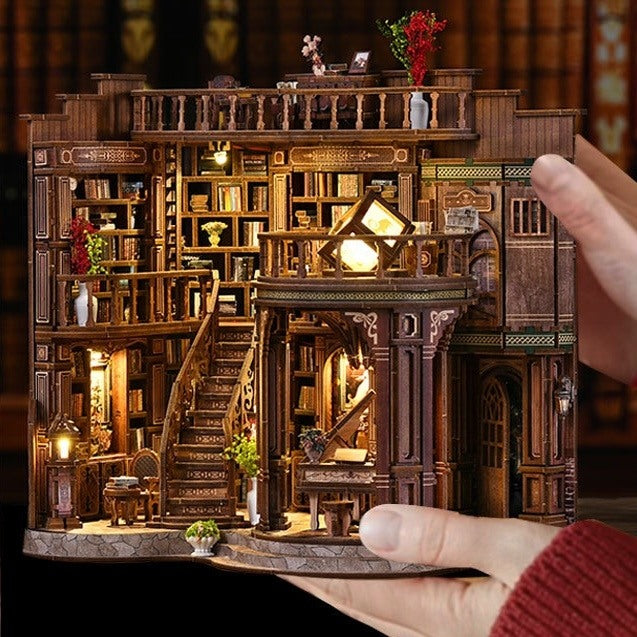 Hand holding a detailed Dreamy Book Hall of a library with bookshelves and decorative elements.