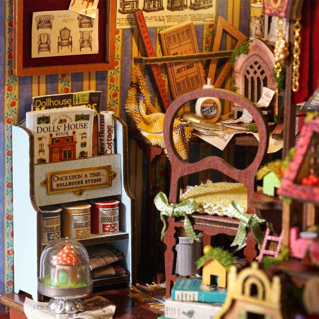 Miniature dollhouse furniture and books arranged on a shelf with a colorful background.
