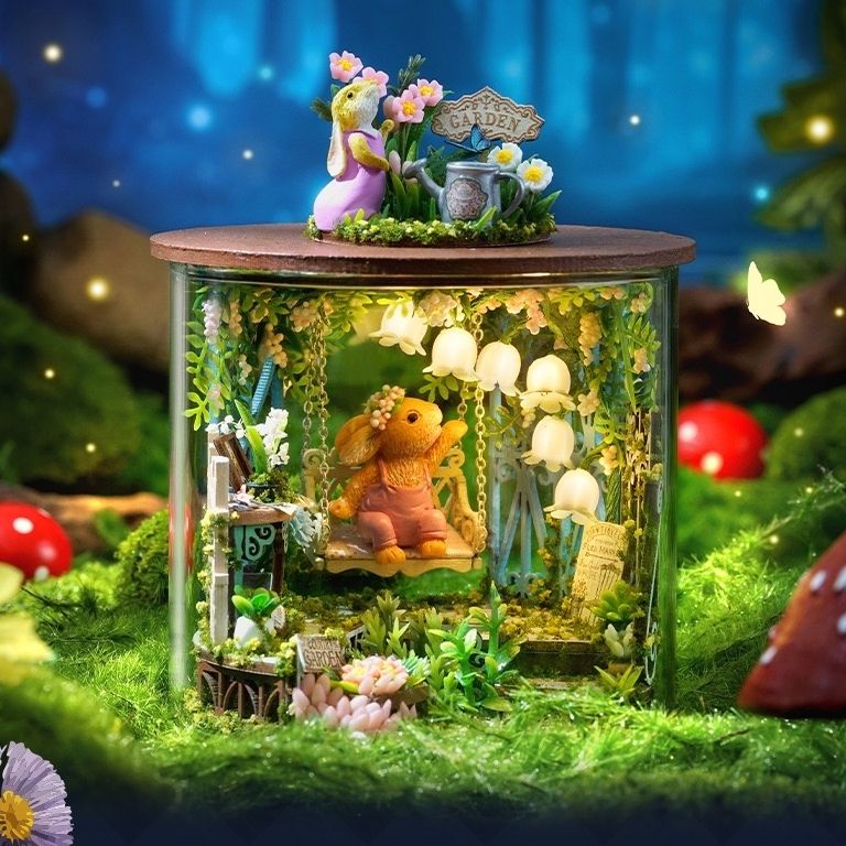 image displaying an assembled Fairytale Garden DIY Miniature House Kit with lights on in a magic forest setting