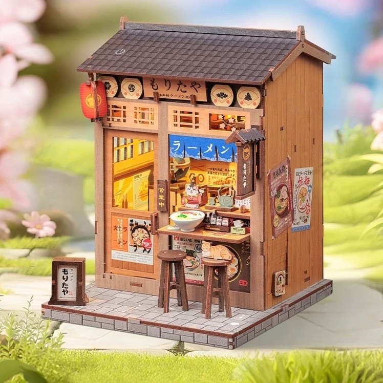 Miniature model of a Japanese ramen shop with cherry blossoms in the background