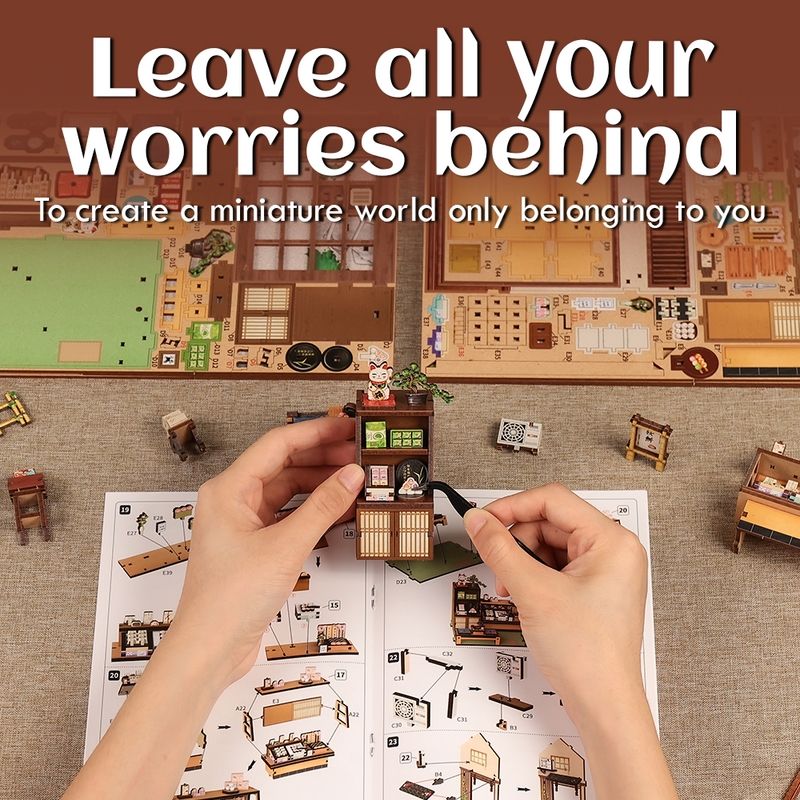 Miniature model being assembled with text 'Leave all your worries behind' on a brown background