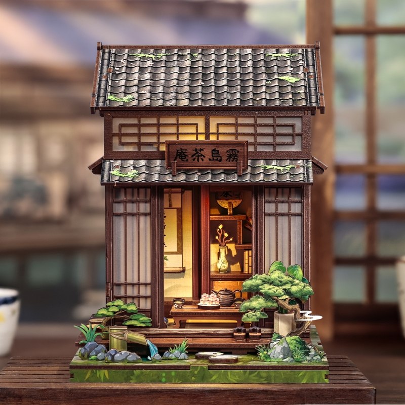 Wooden miniature house model of a traditional Japanese tea house with greenery and a blurred background