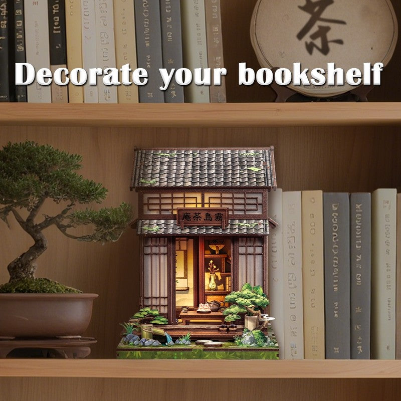 Bookshelf with decorative miniature Japanese tea house building, bonsai tree, and books.