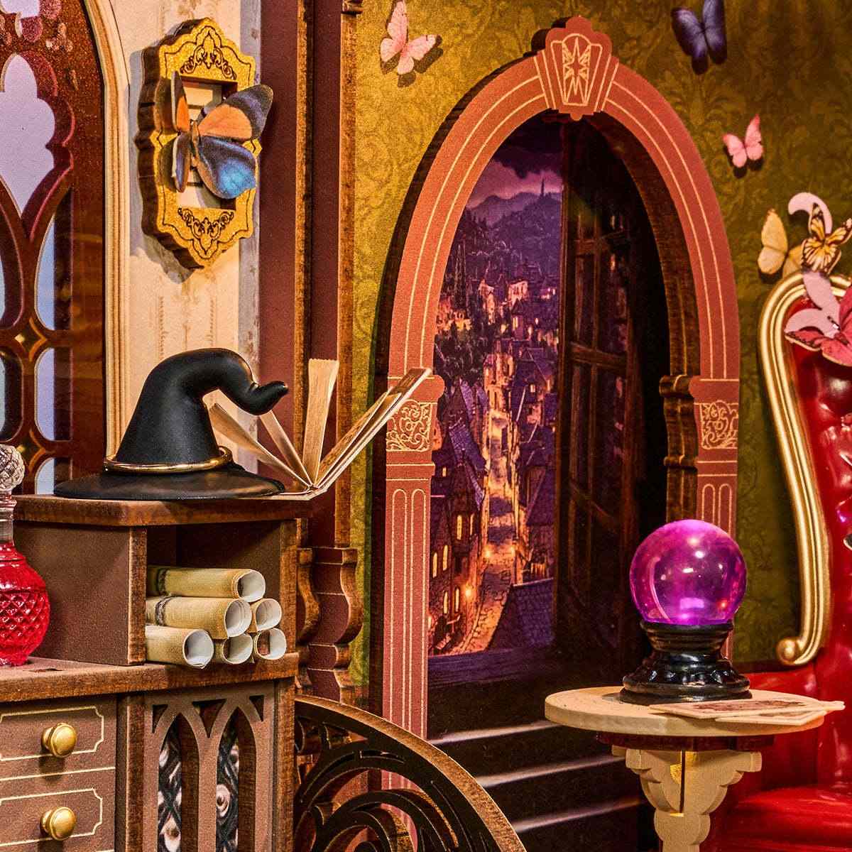 miniature interior with a book, hat, and purple crystal ball in a fantasy setting.