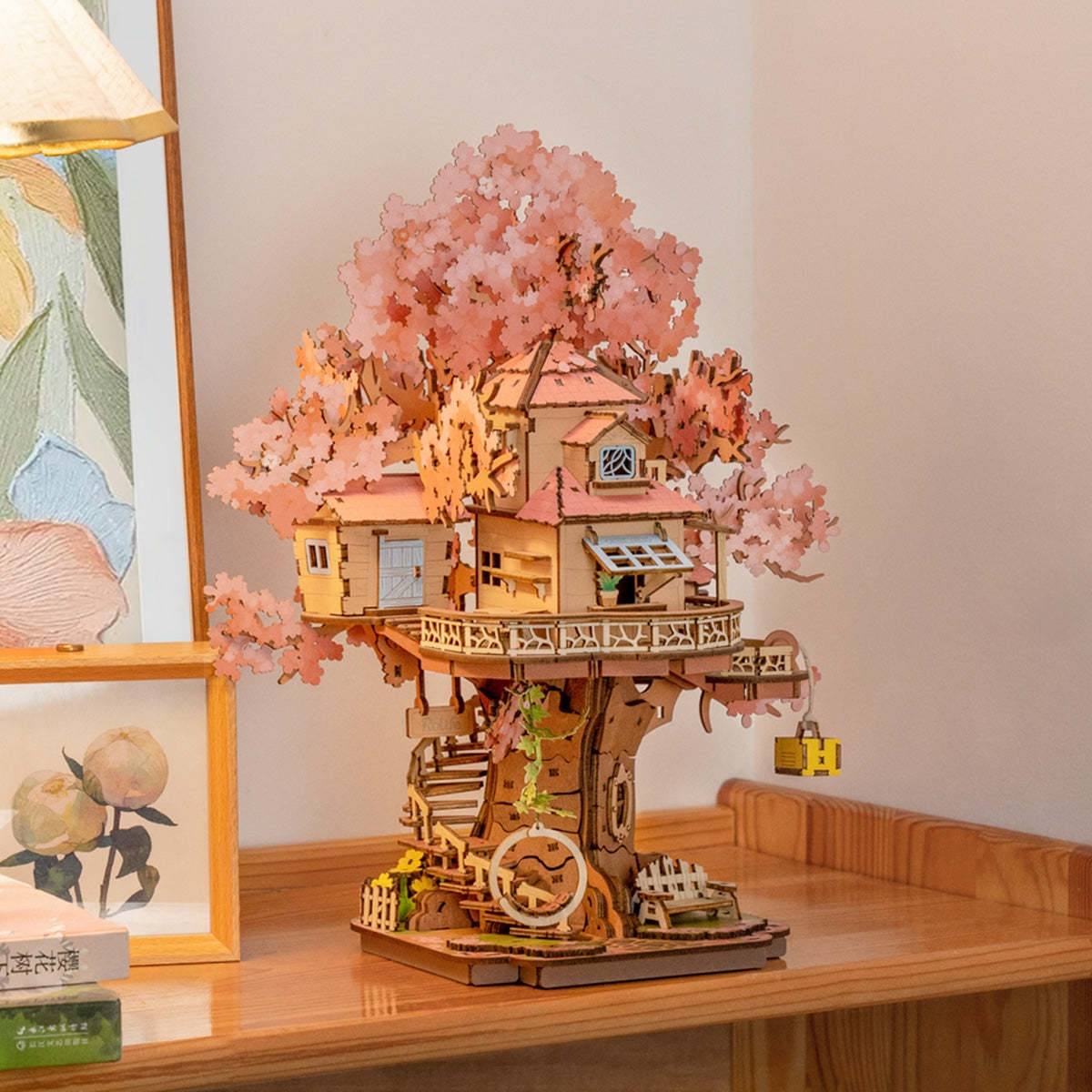 assembled Wooden treehouse model with cherry blossoms on a wooden table