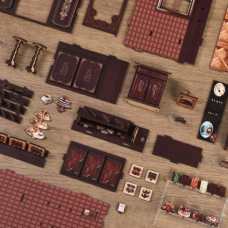 Collection of miniature furniture and decorative items of Sweet Chapter Wooden Book Nook on a textured surface