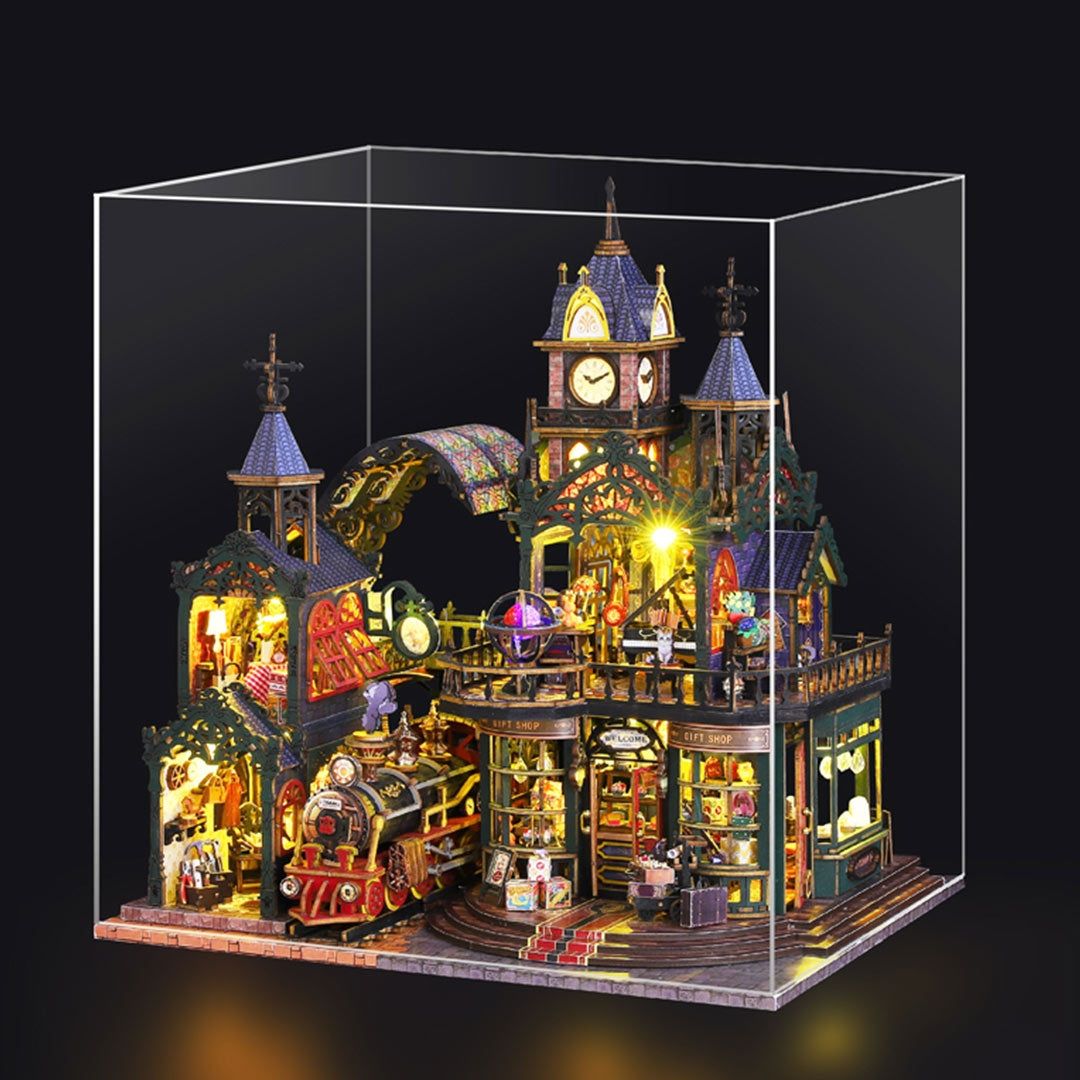 Detailed miniature house model of Victorian-style steampunk railway station in a clear dust-proof display case.