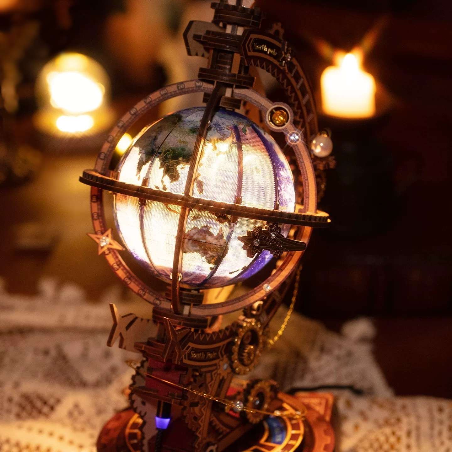 Decorative lit metal globe model with mechanical elements on a blurred background