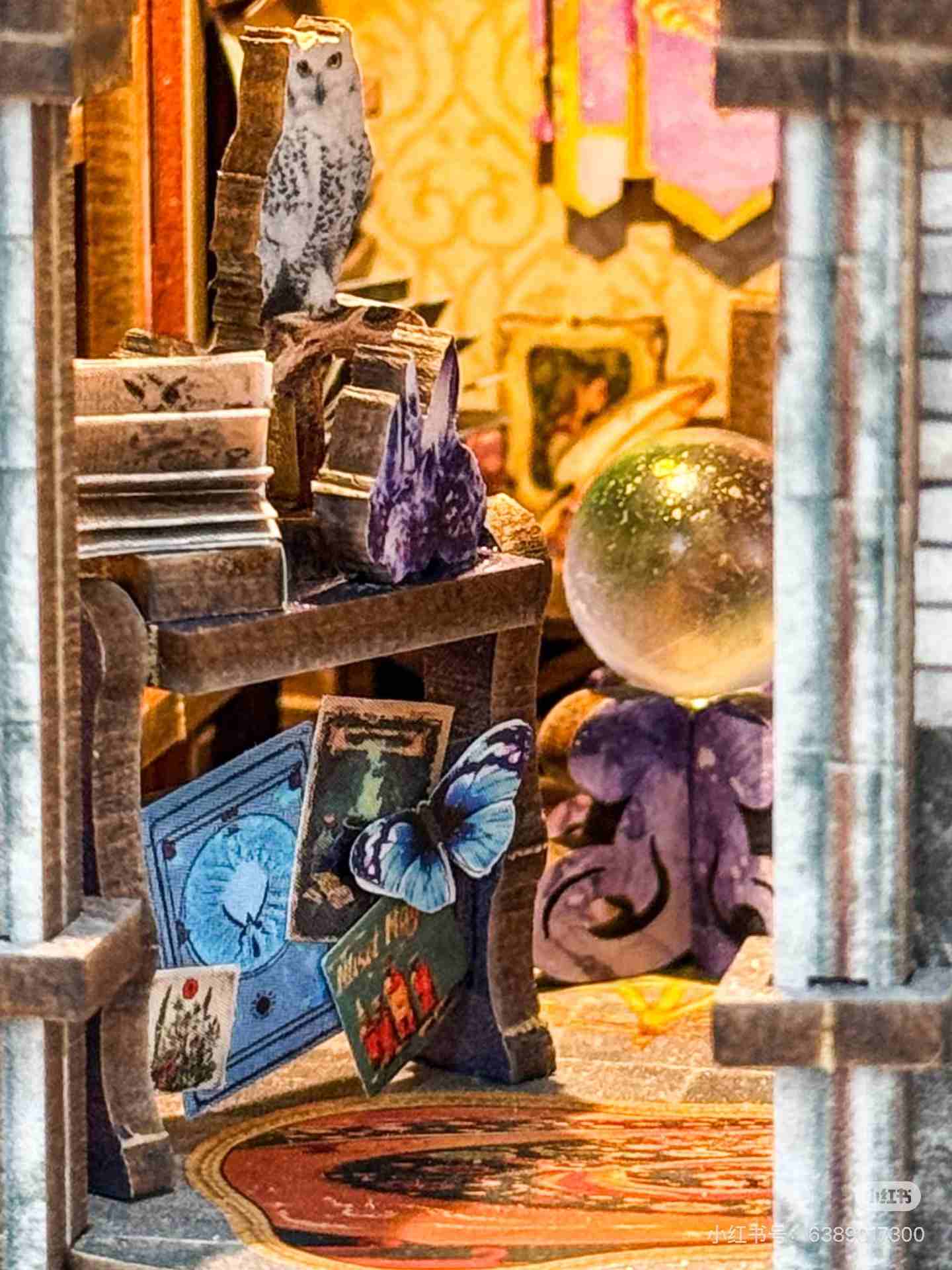 miniature wooden shelf with books, a owl figurine, and other items in a magical shop setting