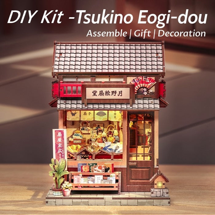 DIY Miniature Craft Kit model of a traditional Japanese building on a wooden surface with text indicating assembly, gift, and decoration.