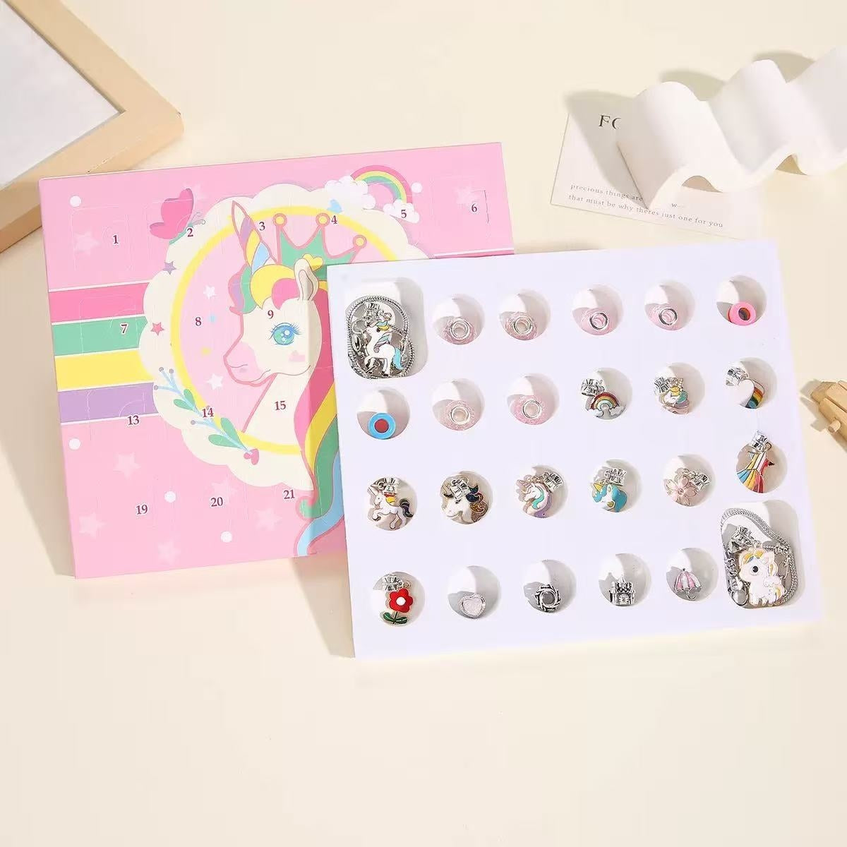 Set of unicorn-themed earrings on a countdown surprise box with a pink card featuring a unicorn design.