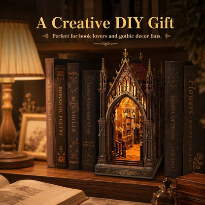 A decorative gothic cathedral-style miniature book nook set on a wooden shelf, surrounded by faux books, with a lamp and books in the background. Text at the top reads 'A Creative DIY Gift' and 'Perfect for book lovers and gothic decor fans.