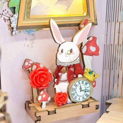 Decorative miniature clock with a rabbit design and red flowers on a wooden base.