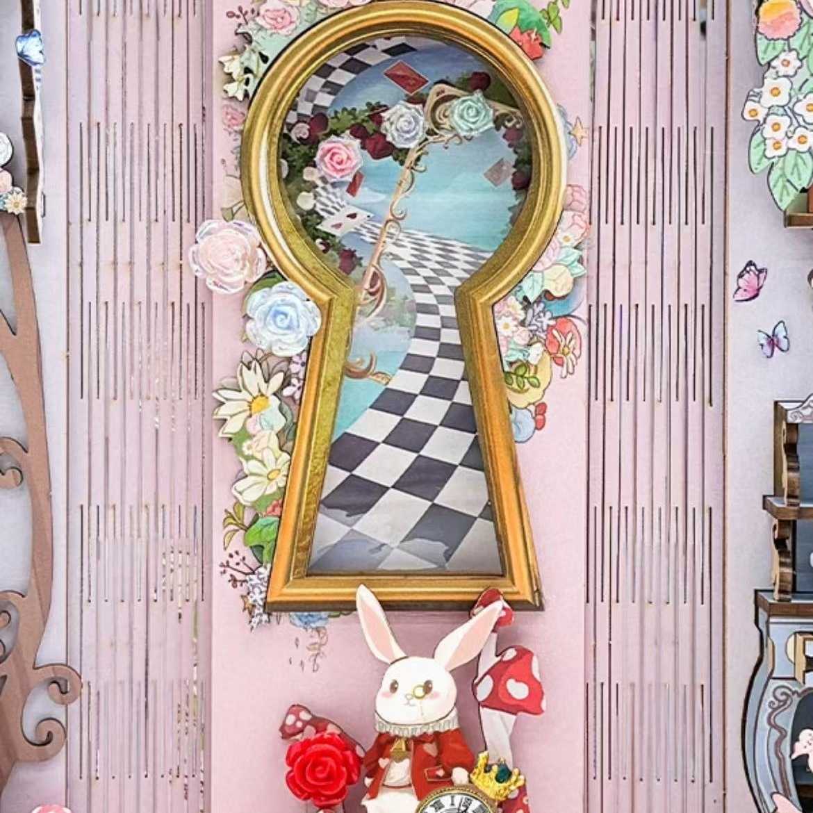 wall art inside a book nook with a keyhole frame, floral elements, and a rabbit figure on a checker path