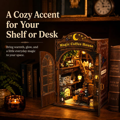 A decorative miniature coffee shop shelf or desk accessory shaped like an open 'Magic Coffee House' cabinet, shown lit with warm interior lights on a wooden shelf beside books and a candle. Large promotional text appears on the left.