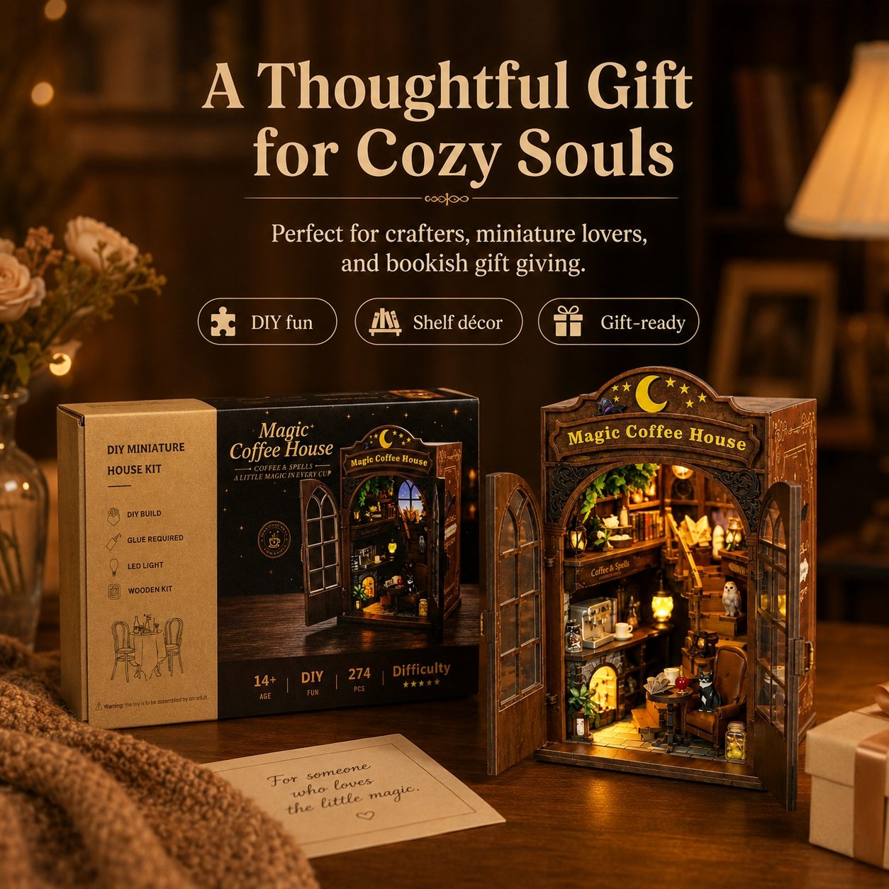 DIY miniature house kit labeled 'Magic Coffee House' shown with its retail box, assembled display model, and a card on a wooden table in a cozy warmly lit room. Large promotional text at the top reads 'A Thoughtful Gift for Cozy Souls.
