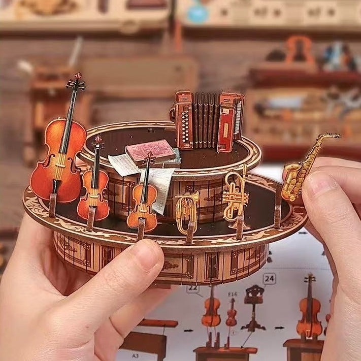 Hand holding a wooden miniature model of a music-themed puzzle with instruments.