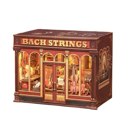 miniature house model with 'Bach Strings' text and warm light casting through the windows and door