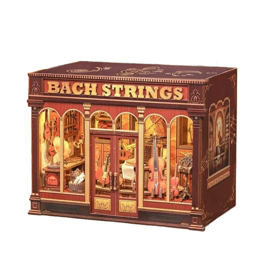 miniature house model with 'Bach Strings' text and warm light casting through the windows and door