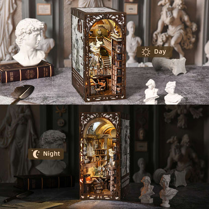 Light-up book nook model of a Baroque miniature studio room with changing lighting conditions from day to night, surrounded by classical sculptures.