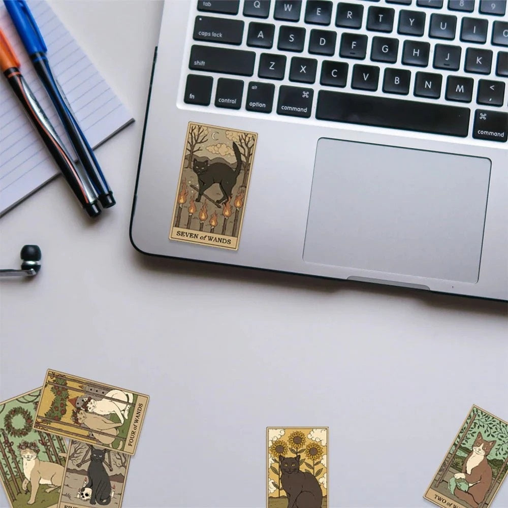 Laptop with tarot card-style stickers on a desk