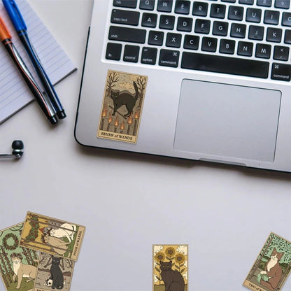 Laptop with tarot card-style stickers on a desk
