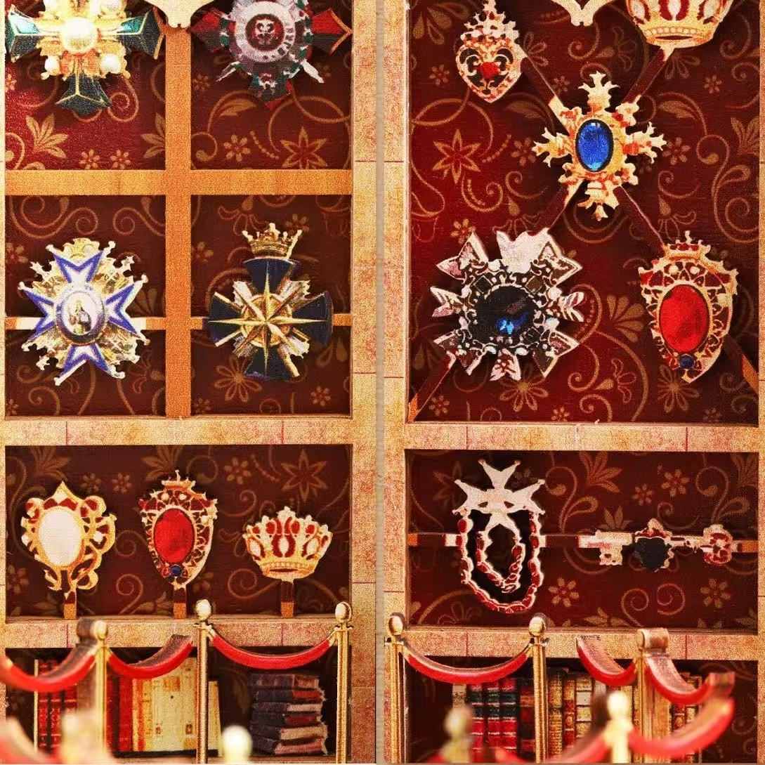 Decorative wall with ornate emblems and crowns in a museum-themed miniature house