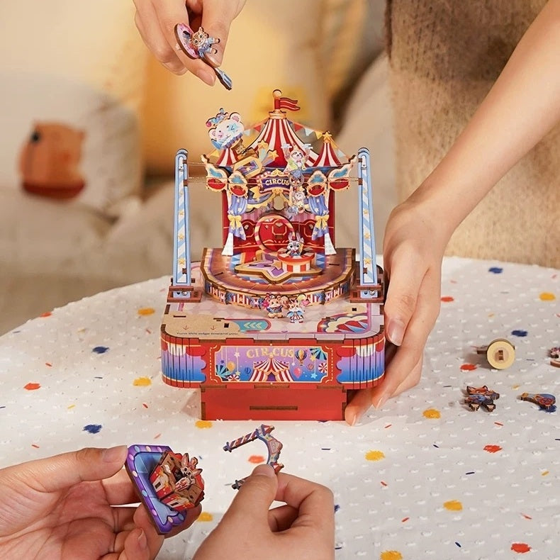 Circus-themed music box with decorative figures on a table.