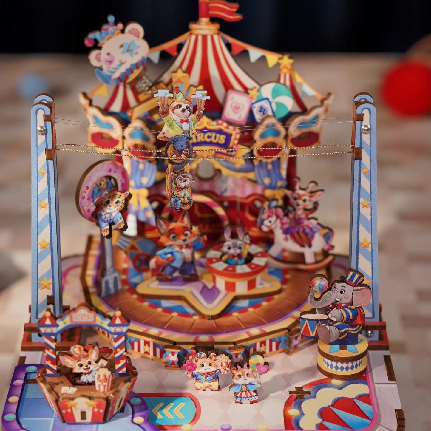 Colorful circus-themed 3D wooden model set with various characters and a large tent-like structure.