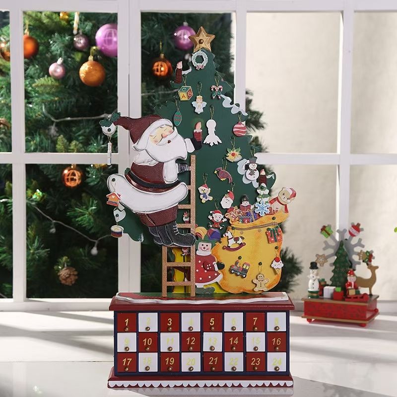 Christmas Countdown Wooden Advent Calendar featuring Santa climbing up a ladder alongside a decorated Christmas tree, 24 drawers on the base