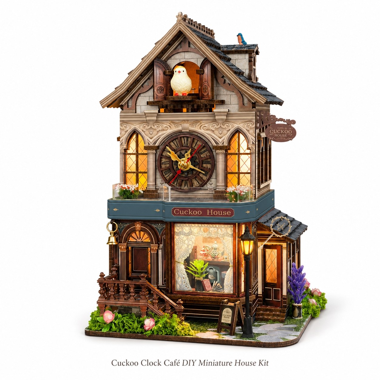 Cuckoo Clock Cafe DIY Miniature House Kit, featuring a highly detailed, multi-story miniature house with a cuckoo clock on the facade, warm glowing windows, a front porch, and decorative garden elements, shown against a plain white background.