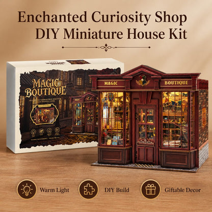 Enchanted Curiosity Shop DIY Miniature House Kit shown with its retail box and the assembled miniature shop model on a wood surface. The box reads 'Magic Boutique' and the assembled shop features warm glowing windows, dark red-brown exterior panels, and decorative signage.