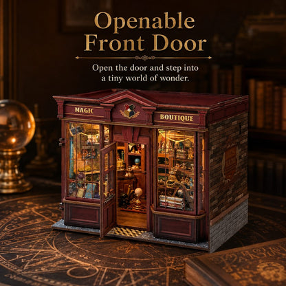 A miniature fantasy shop model with an open front door, labeled 'MAGIC' and 'BOUTIQUE', displayed on a dark wooden surface with decorative books and a brass globe in the background. Text at the top reads 'Openable Front Door' with descriptive copy.
