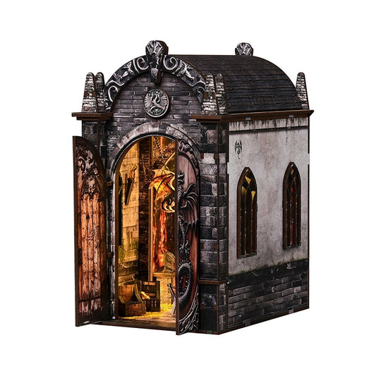 Decorative book nook model of a mysterious realm stone building with an open door revealing a warm glow inside.