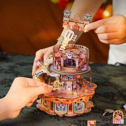  hands holding a colorful Coco-inspired 3D puzzle model of a music box with intricate details