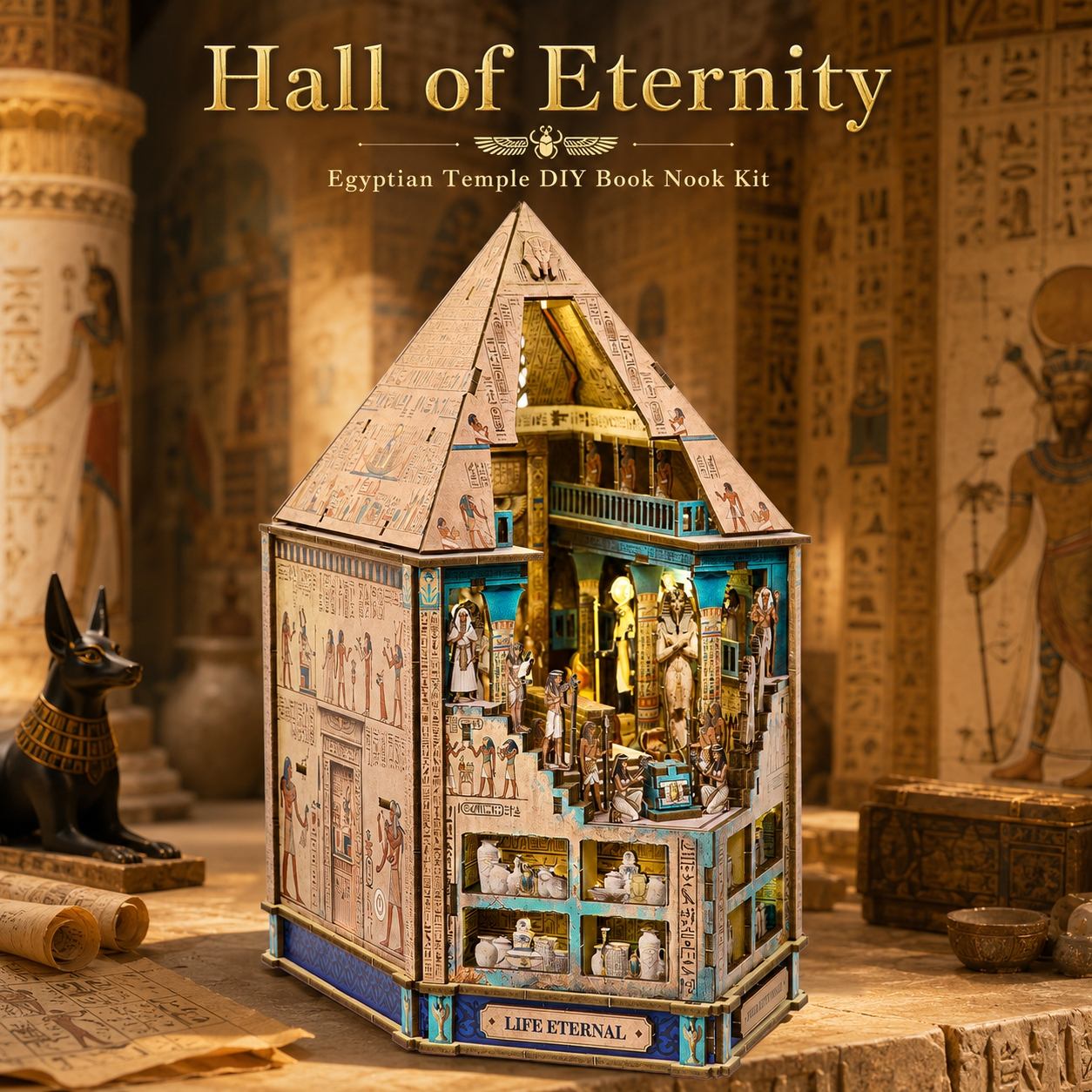 A 3D wooden book nook kit shaped like an Egyptian temple, labeled 'Hall of Eternity' at the top and 'Life Eternal' on the front. The kit is displayed in a beautifully styled ancient Egyptian-themed setting with hieroglyphics, scrolls, and a black Anubis statue.