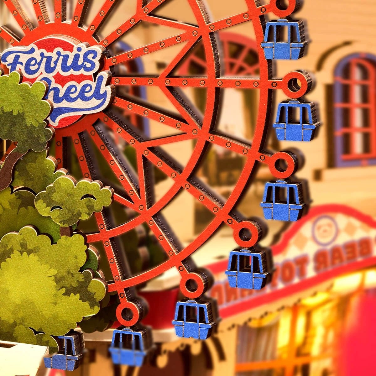 miniature Model of a Ferris wheel with blue gondolas in front of a building with a sign.