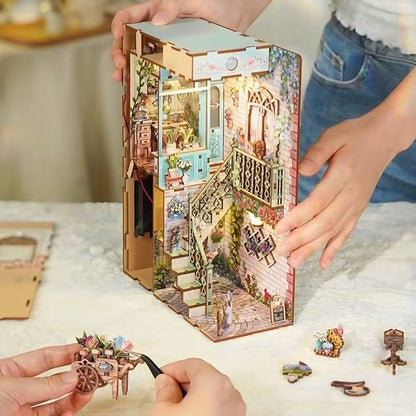 Puzzle model of a miniature house with detailed interior and decorative elements, held by hands on a light surface.