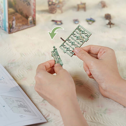 Hands holding a small metal puzzle piece on a soft surface with a green arrow pointing to it.