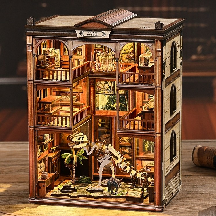 Wooden book nook model of a museum with various exhibits on a wooden floor.