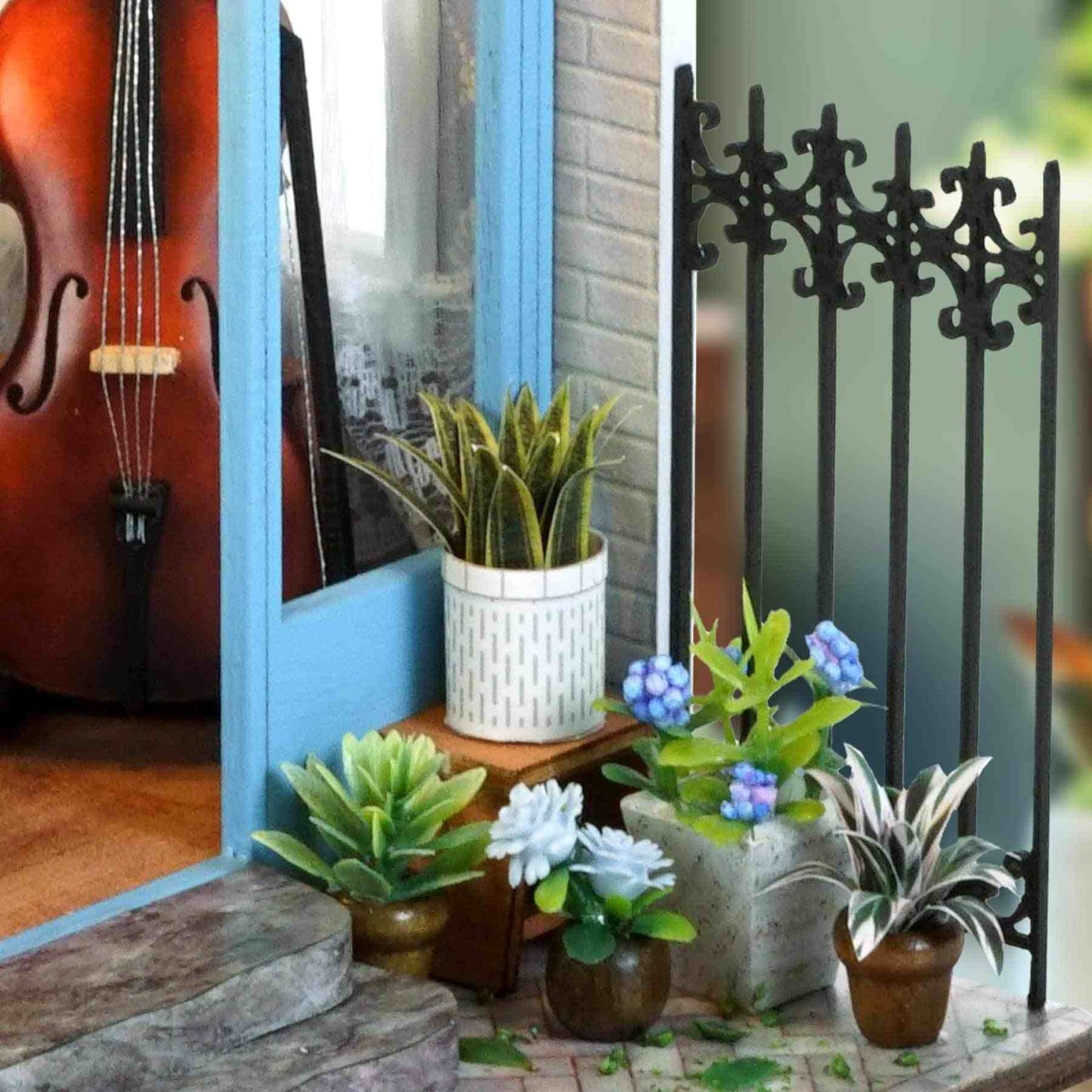 miniature Decorative plants in pots on a ledge with a guitar and decorative metal railing in a Garden Music House Dollhouse