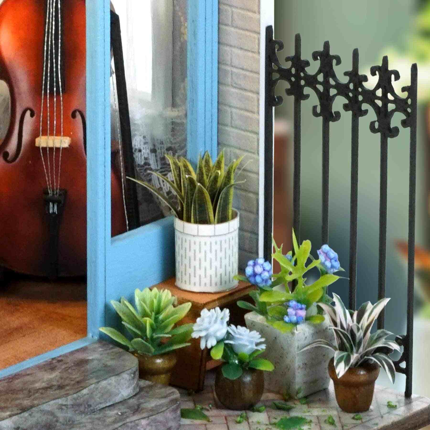 miniature Decorative plants in pots on a ledge with a guitar and decorative metal railing in a Garden Music House Dollhouse