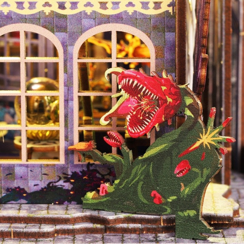 man-eating flower model in front of a miniature house with decorative elements.